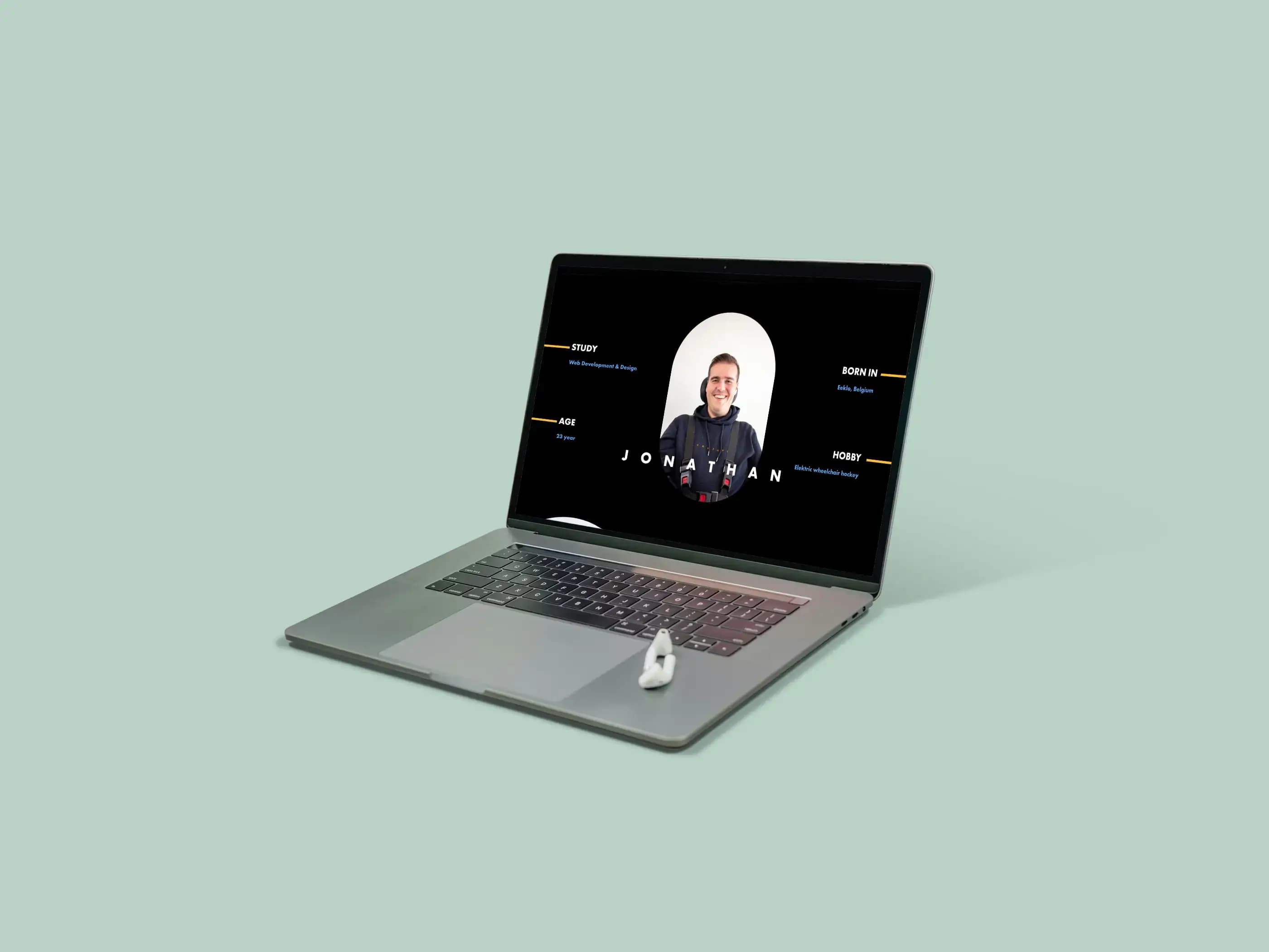 Dark grey laptop shows a personal portfolio website with a man's profile photo.